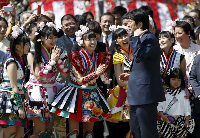 Japan's Prime Minister Shinzo Abe (front R) talks with members of Japanese idol group Momoiro Clover Z at a cherry blossom viewing party at Shinjuku Gyoen park in Tokyo April 18, 2015. (Photo by Issei Kato/Reuters)