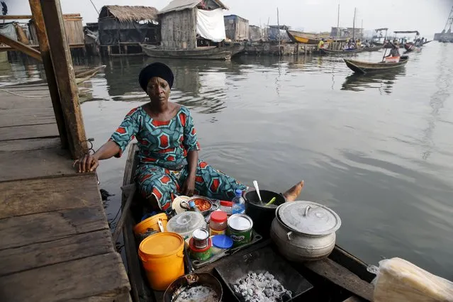 A woman cooks on a canoe in the Makoko fishing community on the Lagos Lagoon, Nigeria February 29, 2016. (Photo by Akintunde Akinleye/Reuters)