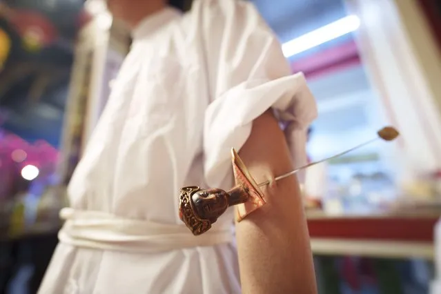 Ethnic Chinese devotees are pierced with a metal rod on their arm as they prepare for a procession during Wangkang or “royal ship” festival at Yong Chuan Tian Temple in Malacca, Malaysia, Thursday, January 11, 2024. (Photo by Vincent Thian/AP Photo)