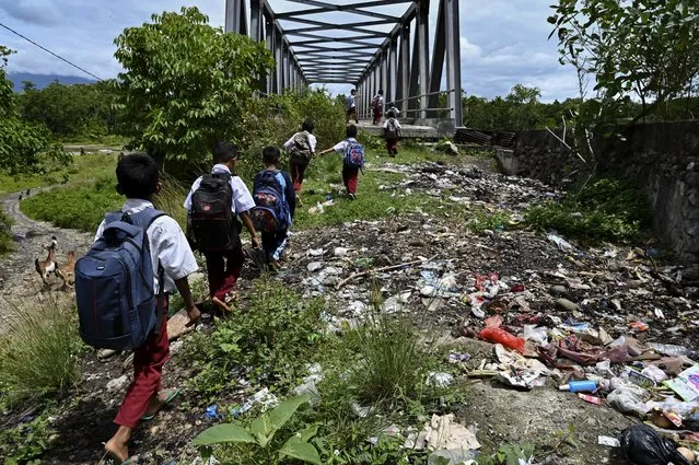Pupils walk to a bridge after school in a remote village in Panca, Aceh province on September 29, 2021. (Photo by Chaideer Mahyuddin/AFP Photo)