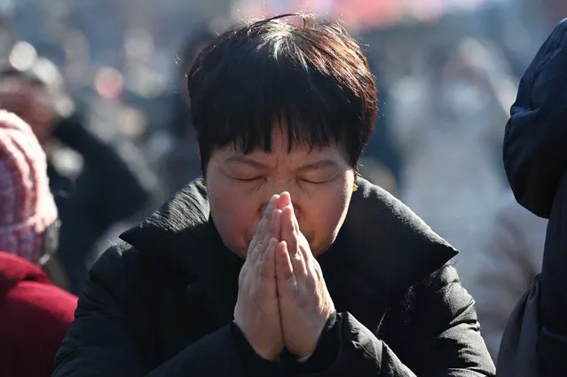 A woman prays at the Lama Temple on the first day of the Lunar New Year of the Dragon in Beijing on February 10, 2024. (Photo by Greg Baker/AFP Photo)