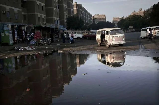 Teenagers make their way to school as a driver tries to fix his mini bus in Giza, Egypt, Thursday, November 17, 2016. Egypt is currently suffering an acute foreign currency shortage because of the decimation of its lucrative tourism industry, double digit rates of inflation and unemployment. (Photo by Nariman El-Mofty/AP Photo)