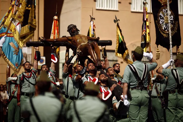 Spanish legionnaires carry a statue of the Christ of Mena outside a church during a ceremony before they take part in the “Mena” brotherhood procession in Malaga, southern Spain, March 24, 2016. (Photo by Jon Nazca/Reuters)