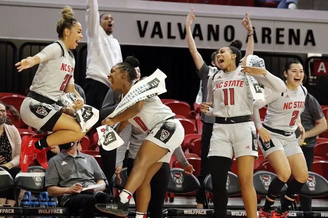 North Carolina State's Madison Hayes (21), Diamond Johnson (0), Jakia Brown-Turner (11) and Raina Perez (2) celebrate their win over Towson in an NCAA college basketball game, Monday, November 15, 2021, in Raleigh, N.C. (Photo by Karl B. DeBlaker/AP Photo)