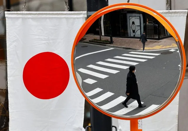 Pedestrians are reflected on a curved mirror next to Japan’s national flag in a shopping district in Tokyo, Japan on March 19, 2024. (Photo by Kim Kyung-Hoon/Reuters)
