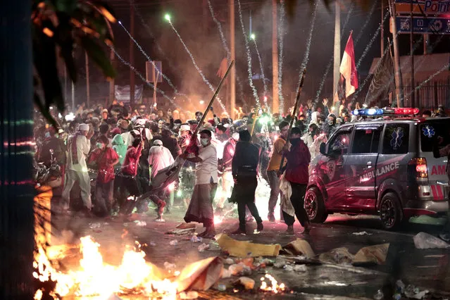 Fire crackers explode near supporters of presidential candidate Prabowo Subianto during clashes with the police in Jakarta, Indonesia, Wednesday, May 22, 2019. Indonesian President Joko Widodo said authorities have the volatile situation in the country's capital under control after six people died Wednesday in riots by supporters of his losing rival in last month's presidential election. (Photo by Dita Alangkara/AP Photo)