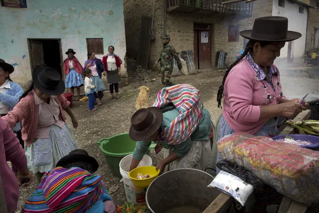 In this March 29, 2016 photo, women prepare lunch during a group burial for people who were slain more than two decades ago by Shining Path guerrillas, in Ccano, a village in the Huanta area of Ayachcuo department, Peru. In Ccano, many peasants worked with the military to fight the rebels. The Shining Path stormed a church here in retaliation, killing everyone praying inside in 1991. (Photo by Rodrigo Abd/AP Photo)