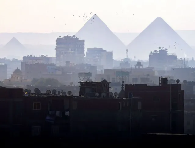 A general view of fog over the Great Pyramids and old houses in Cairo, Egypt on 24 January 2024. (Photo by Amr Abdallah Dalsh/Reuters)