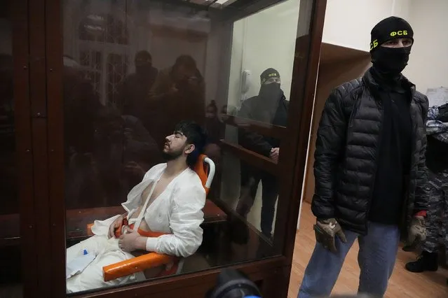 Mukhammadsobir Faizov, a suspect in Friday's shooting at the Crocus City Hall, sits in a glass cage in the Basmanny District Court in Moscow, Russia, Sunday, March 24, 2024. (Photo by Alexander Zemlianichenko/AP Photo)