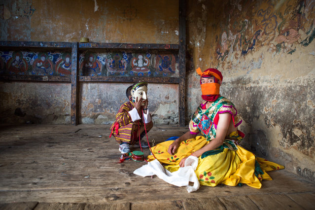 “A young boy tries on the mask of a masked dancer who is having a breather after his physically grueling dance, at the festival at Tamshing Lhakhang in Bumthang, Bhutan. September 2013”. (Photo and caption by Joyce Le Mesurier/2014 Sony World Photography Awards)