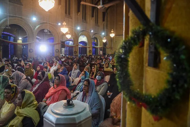 In this picture taken on December 24, 2021, Christian devotees pray at Saint Andrew Church to celebrate Christmas in Karachi. (Photo by Rizwan Tabassum/AFP Photo)