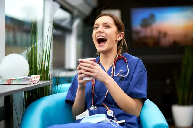 A health worker enjoys a hot drink onboard the Well-being bus at Homerton University hospital in London on February 3, 2021. The bus, which is staffed by volunteer aircrew, is providing free drinks and snacks to NHS staff at the hospital as part of project wingman. (Photo by John Walton/PA Images via Getty Images)