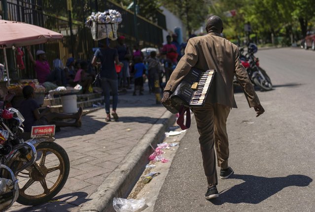 A man carries an accordion in Port-au-Prince, Haiti, April 28, 2024. (Photo by Ramon Espinosa/AP Photo)