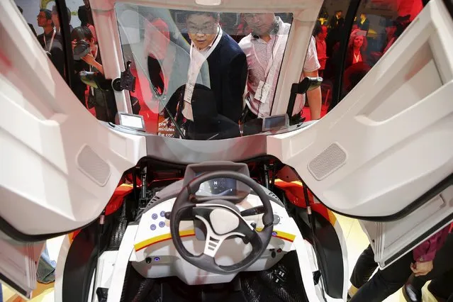 People look inside a high-efficiency petrol-burning concept car as it is unveiled by Royal Dutch Shell during a ceremony in Beijing, China April 22, 2016. (Photo by Damir Sagolj/Reuters)
