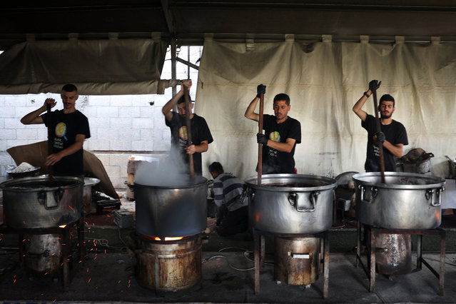 Local volunteers of the World Central Kitchen cook meals to be distributed to needy Palestinians in Rafah in the southern Gaza Strip on May 3, 2024, amid the ongoing conflict between Israel and the Hamas movement. (Photo by AFP Photo/Stringer)