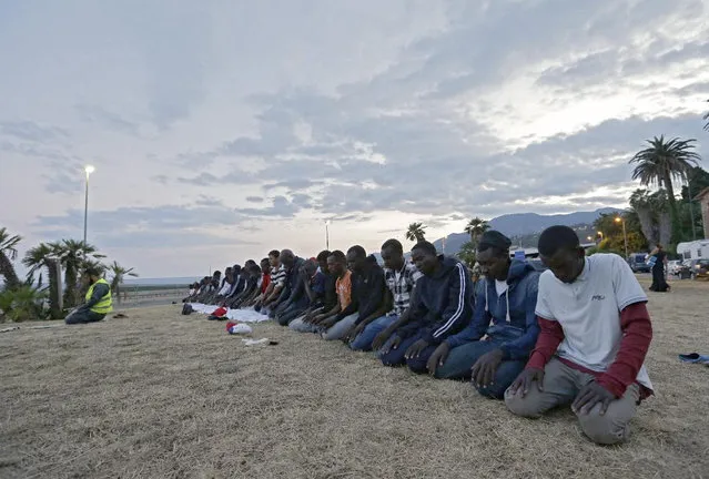 Migrants kneel in prayer at the Franco-Italian border in Ventimiglia, Italy, Wednesday, June 17, 2015. European Union nations failed to bridge differences Tuesday over an emergency plan to share the burden of the thousands of refugees crossing the Mediterranean Sea, while on the French-Italian border, police in riot gear forcibly removed dozens of migrants. (AP Photo/Lionel Cironneau)