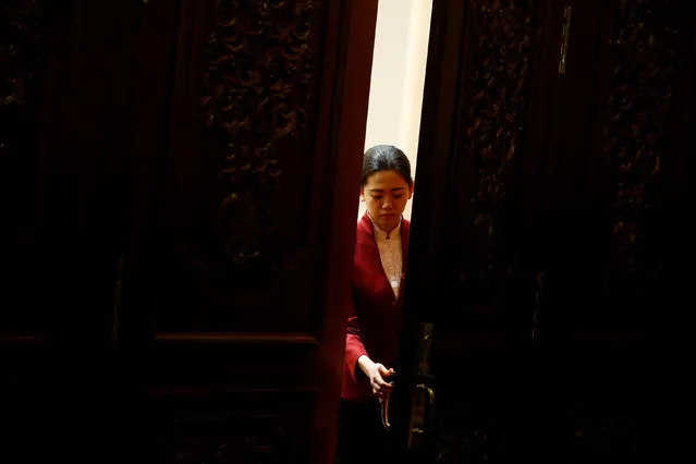 An attendant closes the door to a session room during the National People's Congress at the Great Hall of the People in Beijing, China, March 7, 2017. (Photo by Thomas Peter/Reuters)