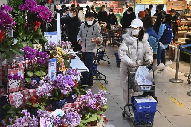 In this photo released by Xinhua News Agency, residents wearing face masks to protect from the coronavirus shop for groceries at a supermarket in Qujiang New District of Xi'an in northwestern China's Shaanxi Province on January 15, 2022. (Photo by Tao Ming/Xinhua via AP Photo)