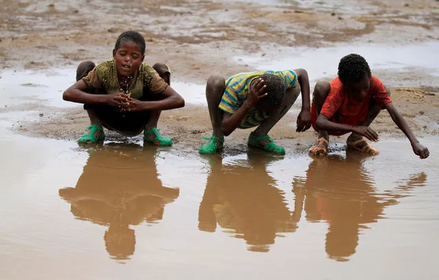 Children wash their heads with rain water in Kobo village, one of the drought stricken areas of Oromia region, in Ethiopia, April 28, 2016. (Photo by Tiksa Negeri/Reuters)