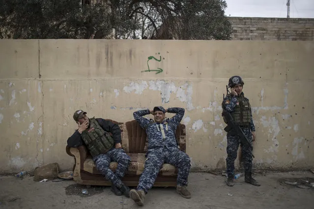 Federal Police officers rest on a couch during fighting between Iraqi security forces and Islamic State militants, on the western side of Mosul, Iraq, Sunday, March 19, 2017. (Photo by Felipe Dana/AP Photo)