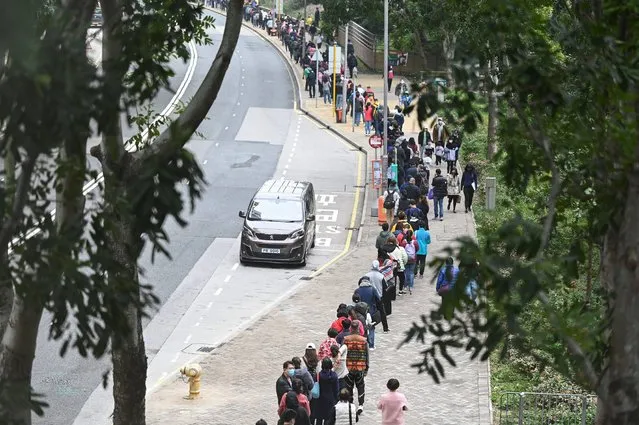 People queue at a mobile specimen collection station for Covid-19 testing in Hong Kong's Tung Chung district on February 10, 2022, as authorities scrambled to ramp up testing capacity following a record high number of new infections. (Photo by Peter Parks/AFP Photo)