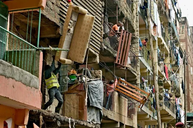 Residents move sofas and beds from a block of flats which is going  which is going to be demolished on May 6, 2016. Following a building collapse which claimed at least 40 lives with more 80 people still unaccounted for, after severe flooding, the government has ordered the demolition of similar unsafe buildings in the area. Located in the poor, tightly-packed Huruma neighbourhood, the building, which housed around 150 families crammed into single rooms, had been slated for demolition after being declared structurally unsound. But an evacuation order for the structure, which was built next to a river just two years ago, was ignored. (Photo by Carl de Souza/AFP Photo)