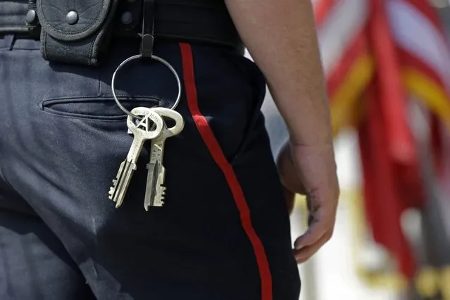 A prison guard, with keys dangling from his belt, stands guard at a locked gate at the arena for the Angola Prison Rodeo in Angola, La., Saturday, April 26, 2014. In a half-century, the event has grown from a small event for prisoners into a big business that draws thousands of spectators to the Louisiana State Penitentiary. Proceeds go into the prison's Inmate Welfare Fund, which helps pay for inmate education and recreational supplies. (Photo by Gerald Herbert/AP Photo)