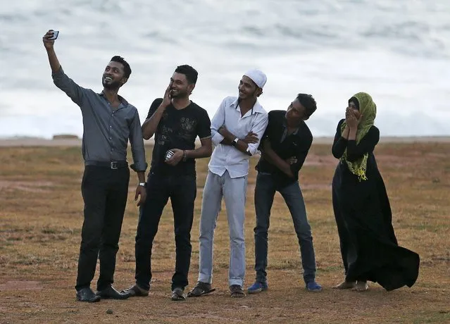 A Muslim youth takes a selfie with his friends before they break their fast at the end of the day during the holy month of Ramadan in Colombo, Sri Lanka, July 8, 2015. (Photo by Dinuka Liyanawatte/Reuters)