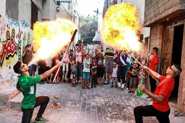 Palestinian members of Gaza's Bar Woolf sports team perform fire breathing as an entertainment for children at the Beach refugee camp, in Gaza City, on June 9, 2021. Egypt has pledged half a billion dollars to rebuild the blockaded Palestinian enclave, which was bombarded by Israel for 11 days during heavy fighting with Hamas which ended with an Egyptian-brokered ceasefire on May 21. (Photo by Majdi Fathi/NurPhoto/Rex Features/Shutterstock)