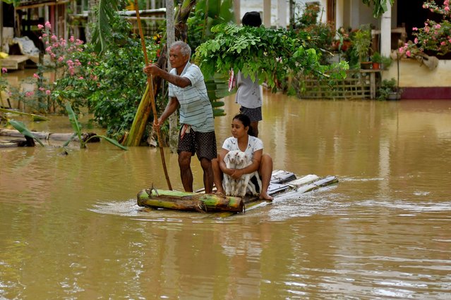 Flood-affected people use a makeshift raft to shift their lamb to a safer place following heavy rains at the Patiapam village in Nagaon district, in the northeastern state of Assam, India on July 3, 2024. (Photo by Anuwar Hazarika/Reuters)