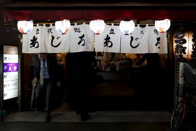 A man walks out of a Japanese pub at a business district in Tokyo, Japan, April 30, 2015. (Photo by Yuya Shino/Reuters)