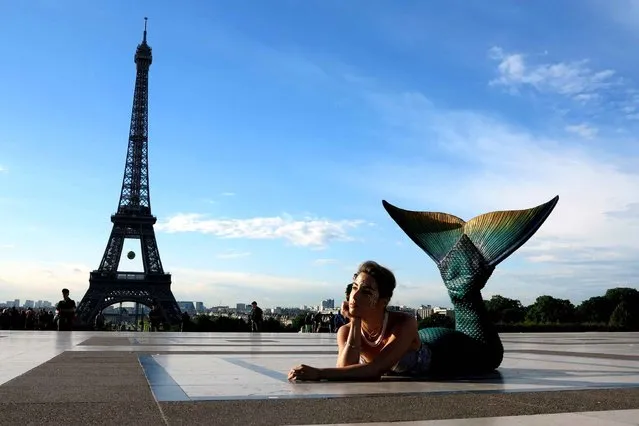 A model dressed as a mermaid poses in front of the Eiffel Tower during sunrise on May 22, 2014 in Paris. (Photo by Ludovic Marin/AFP Photo)