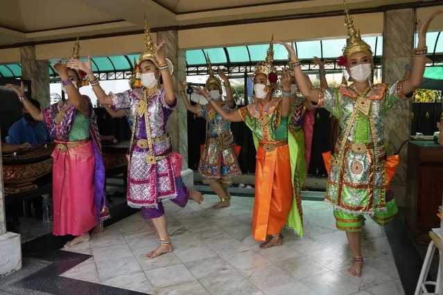 Thai traditional dancers wearing face masks to help protect themselves from the coronavirus perform at the Erawan Shrine in Bangkok, Thailand, Monday, February 7, 2022. (Photo by Sakchai Lalit/AP Photo)