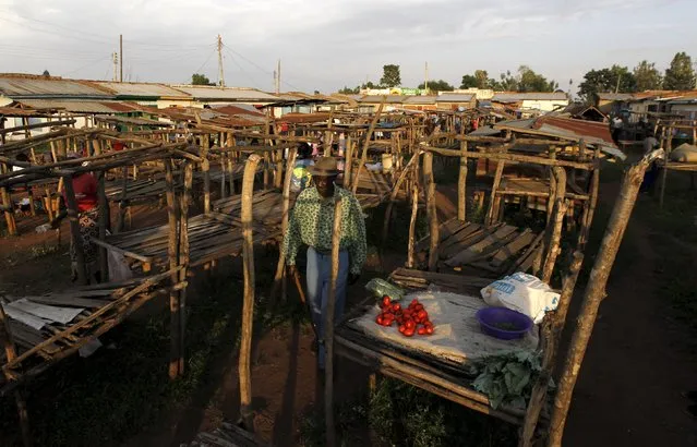 A man walks near wooden stalls at the trading centre in the village of Kogelo, west of Kenya's capital Nairobi, July 15, 2015. (Photo by Thomas Mukoya/Reuters)
