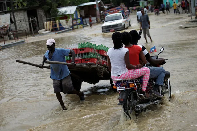 A man pulls a cart as he crosses a flooded street in Leogane, Haiti, May 27, 2016. (Photo by Andres Martinez Casares/Reuters)