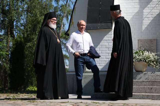 In this pool photograph distributed on July 26, 2024, by Russian state owned Sputnik agency, President Vladimir Putin (C) stands next to Orthodox priests as he visits the Valaam Monastery with the Belarusian President, in nothern Russia on July 25, 2024. (Photo by Alexander Kazakov/AFP Photo)