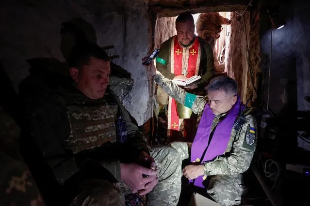 Military chaplains Maksym and Oleksandr conduct an Orthodox Easter service for Ukrainian servicemen at their position, as Russia's attack on Ukraine continues, in Kharkiv region, Ukraine on April 24, 2022. (Photo by Serhii Nuzhnenko/AP Photo)