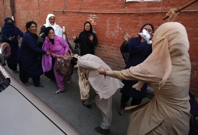 An Indian Police woman officer (R) tries to rescue her colleague (C, light dress) from an angry worker of the Social Welfare department who scuffled with police as they were stopped from protesting in Srinagar, the summer capital of Indian Kashmir, 04 June 2016. Employees of the Social Welfare department are demanding regularisation in their jobs and an increase in their monthly wages. (Photo by Farooq Khan/EPA)