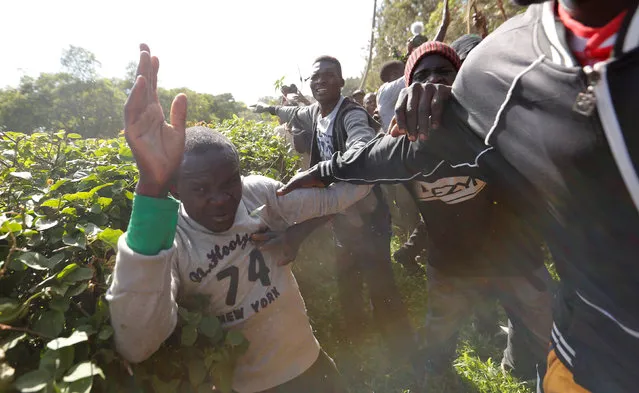 Supporters of Kenya's opposition Coalition for Reforms and Democracy (CORD) accost a man who they say is a pick-pocket during a protest against at the Independent Electoral and Boundaries Commission (IEBC) to demand the disbandment of the electoral body ahead of next year's election in Nairobi, Kenya, June 6, 2016. (Photo by Thomas Mukoya/Reuters)