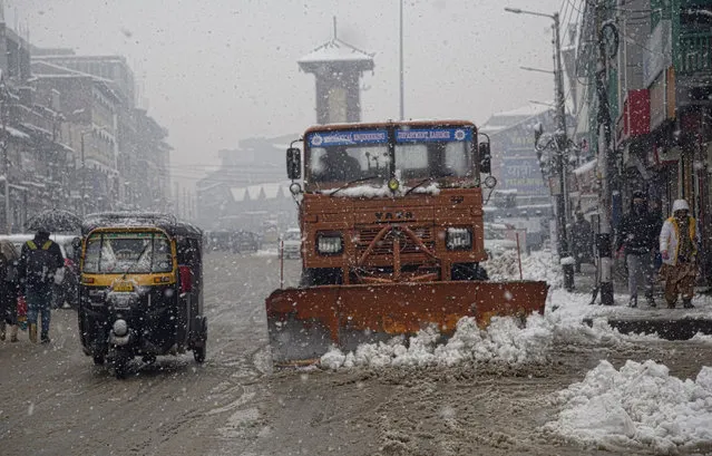 Snowplough removes snow from roads in the city center amid snowfall, on December 13, 2019 in Srinagar, the summer capital of Indian administered Kashmir, India. Indian Administered Kashmir, witnessed heavy snowfall on Friday, leading to the closure of Srinagar Jammu Highway the only road connecting Kashmir with rest of India. (Photo by Yawar Nazir/ Getty Images)