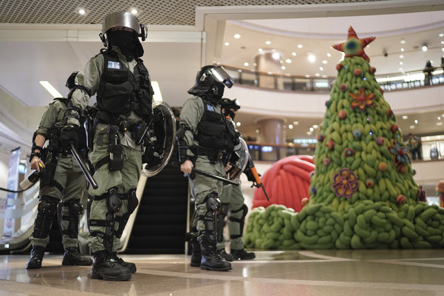 Riot police past by a Christmas decor in a mall during a protest rally on Christmas Eve in Hong Kong on Tuesday, December 24, 2019. (Photo by Kin Cheung/AP Photo)