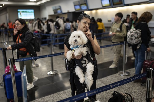 Passenger Maria Lujan holds her dog Maximo Decimo as she talks to an airline worker before check-in at the Jorge Newbery airport in Buenos Aires, Argentina, Thursday, September 19, 2024, during a workers' strike for wage increases that is affecting some flights, but not hers. (Photo by Rodrigo Abd/AP Photo)