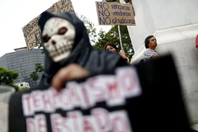 Demonstrators hold sign during a demonstration against the murder of photojournalist Ruben Espinosa and four other women at the Hemiciclo de Juarez monument in Mexico City, August 8, 2015. Espinosa, a prominent Mexican news photographer was among five people found dead in a middle-class neighborhood of the capital on July 31, 2015. (Photo by Edgard Garrido/Reuters)