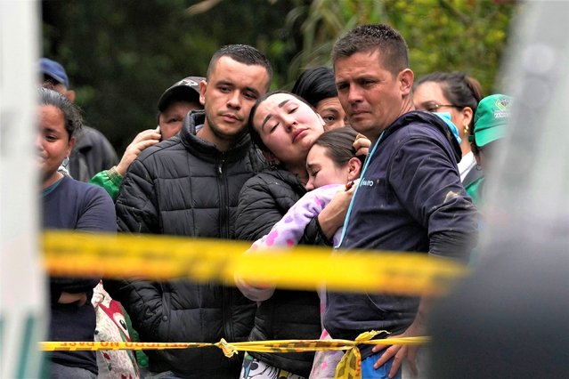 Relatives and friends of people who died in an avalanche watch forensic workers cover the bodies and take them away in El Naranjal, Colombia, Tuesday, July 18, 2023. (Photo by Fernando Vergara/AP Photo)