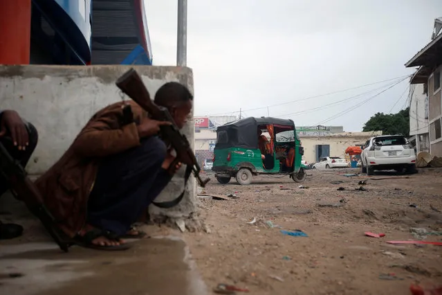 Somali government soldiers hold their positions during gunfire after a suicide bomb attack outside Nasahablood hotel in Somalia's capital Mogadishu, June 25, 2016. Somalia's al Shabaab Islamist group launched a suicide bomb attack on a hotel in the center of Mogadishu on Saturday before fighters stormed inside, police and the militant group said. Police said at least 15 people had died, including guards at the site, civilians and militants. Others were wounded. (Photo by Feisal Omar/Reuters)