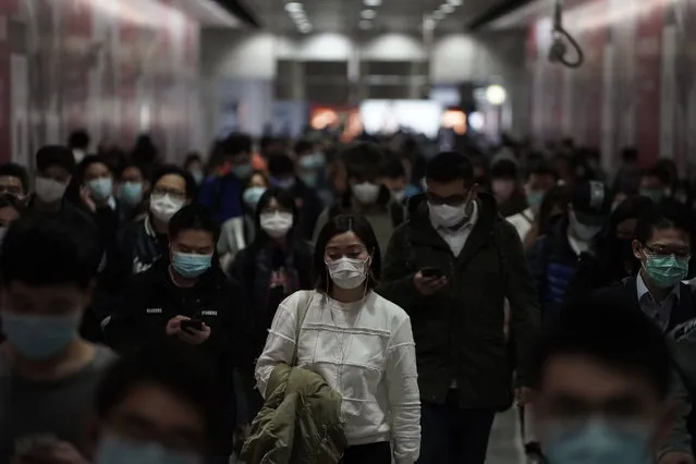 People wearing masks, walk in a subway station, in Hong Kong, Friday, February 7, 2020. Hong Kong on Friday confirmed 25 cases of a new virus that originated in the Chinese province of Hubei. According to the latest figures, 233 new cases of the novel coronavirus have been confirmed globally, Hong Kong's Chief Secretary for Admissions told a news conference. (Photo by Kin Cheung/AP Photo)