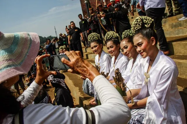 A women are seen photographed the dancers during the “Ngalokat Cai” tradition in Situ Ciburuy, West Java, Indonesia on June 1, 2022. The tradition of “Ngalokat Cai” was held as a form of gratitude from the Ciburuy Community for the abundant water as well as a form of criticism from artists and cultural practitioners against the government due to the loss of their art venues. (Photo by Algi Febri Sugita/ZUMA Press Wire/Alamy Live News)