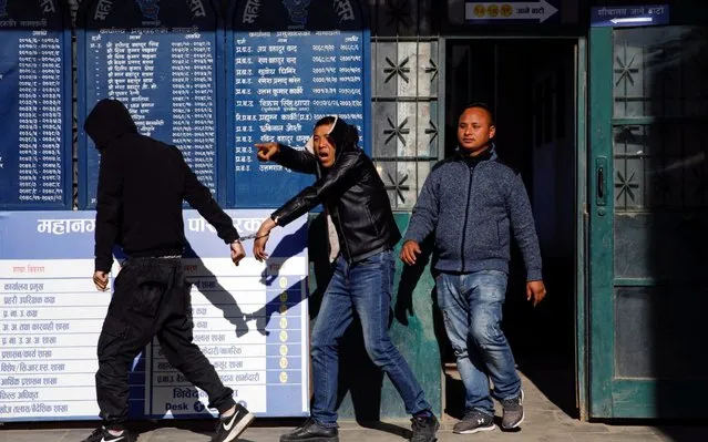 A detained Chinese man reacts towards the media as he walks into the police station in Kathmandu, Nepal on December 24, 2019. (Photo by Navesh Chitrakar/Reuters)