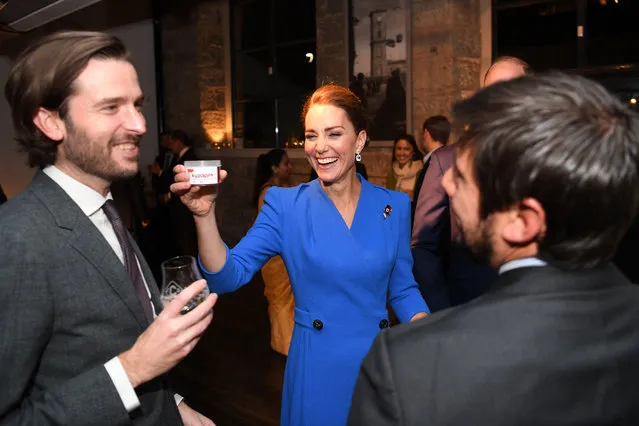 Britain's Catherine, Duchess of Cambridge (C) laughs as she offers a tub of dead larvae, used as livestock feed, to guests at a reception for the key members of the Sustainable Markets Initiative and the Winners and Finalists of the first Earthshot Prize Awards at the Clydeside Distillery, on the sidelines of the COP26 UN Climate Change Conference in Glasgow, Scotland on November 1, 2021. COP26, running from October 31 to November 12 in Glasgow will be the biggest climate conference since the 2015 Paris summit and is seen as crucial in setting worldwide emission targets to slow global warming, as well as firming up other key commitments. (Photo by Daniel Leal-Olivas/Pool via AFP Photo)
