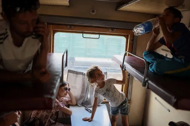People sit in a train to Dnipro and Lviv during an evacuation effort from war-affected areas of eastern Ukraine, amid Russia's invasion of the country, in Pokrovsk, Donetsk region, Ukraine on July 20, 2022. (Photo by Gleb Garanich/Reuters)